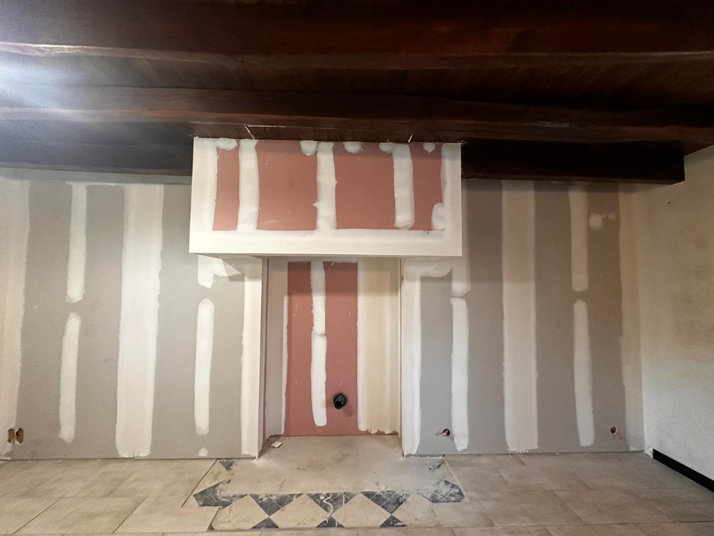 Murs en placo gris et rose technique, niche et poutres apparentes